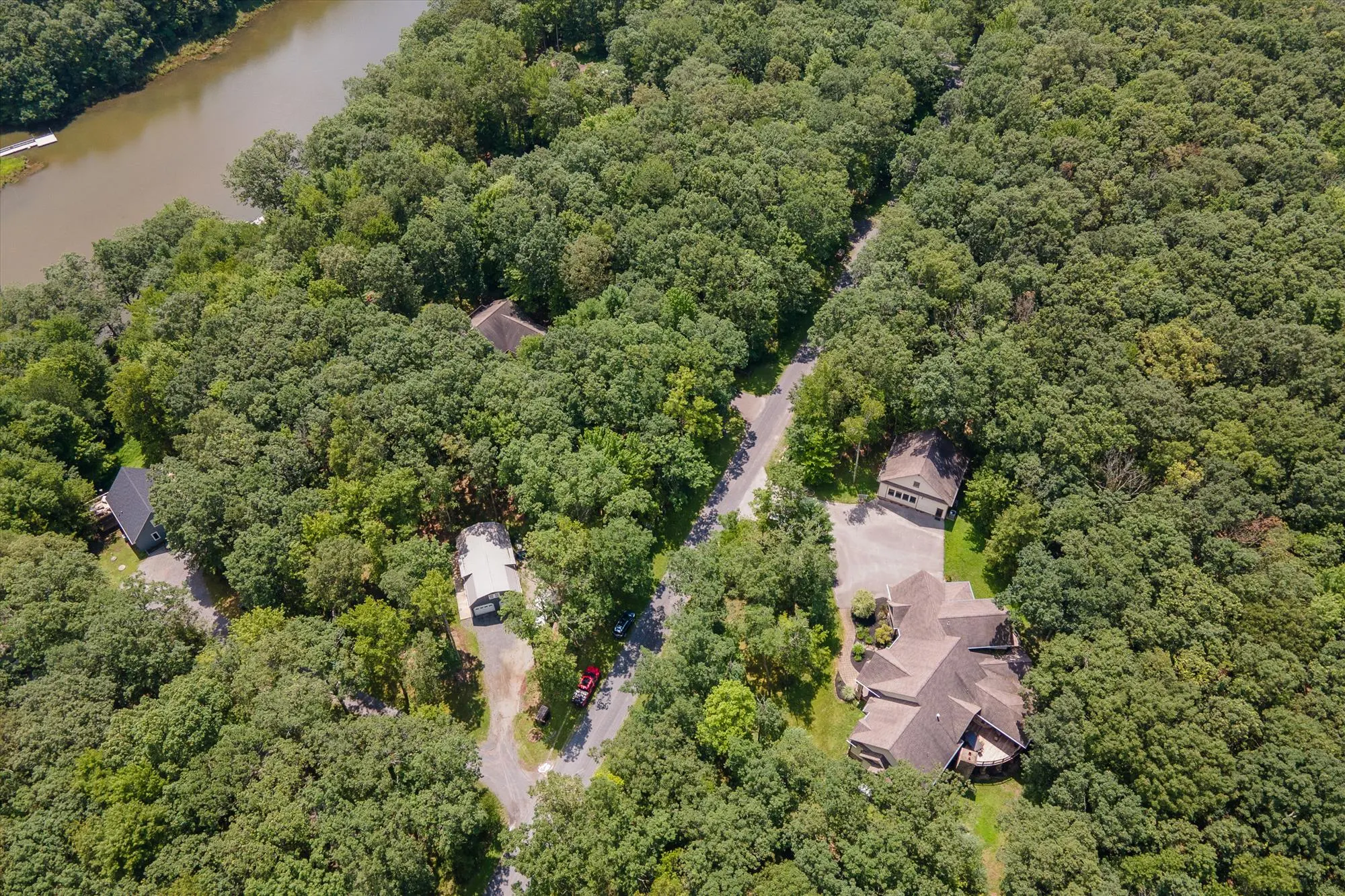 Drone view showing Woodland Chalet property and pool house from above the treetops