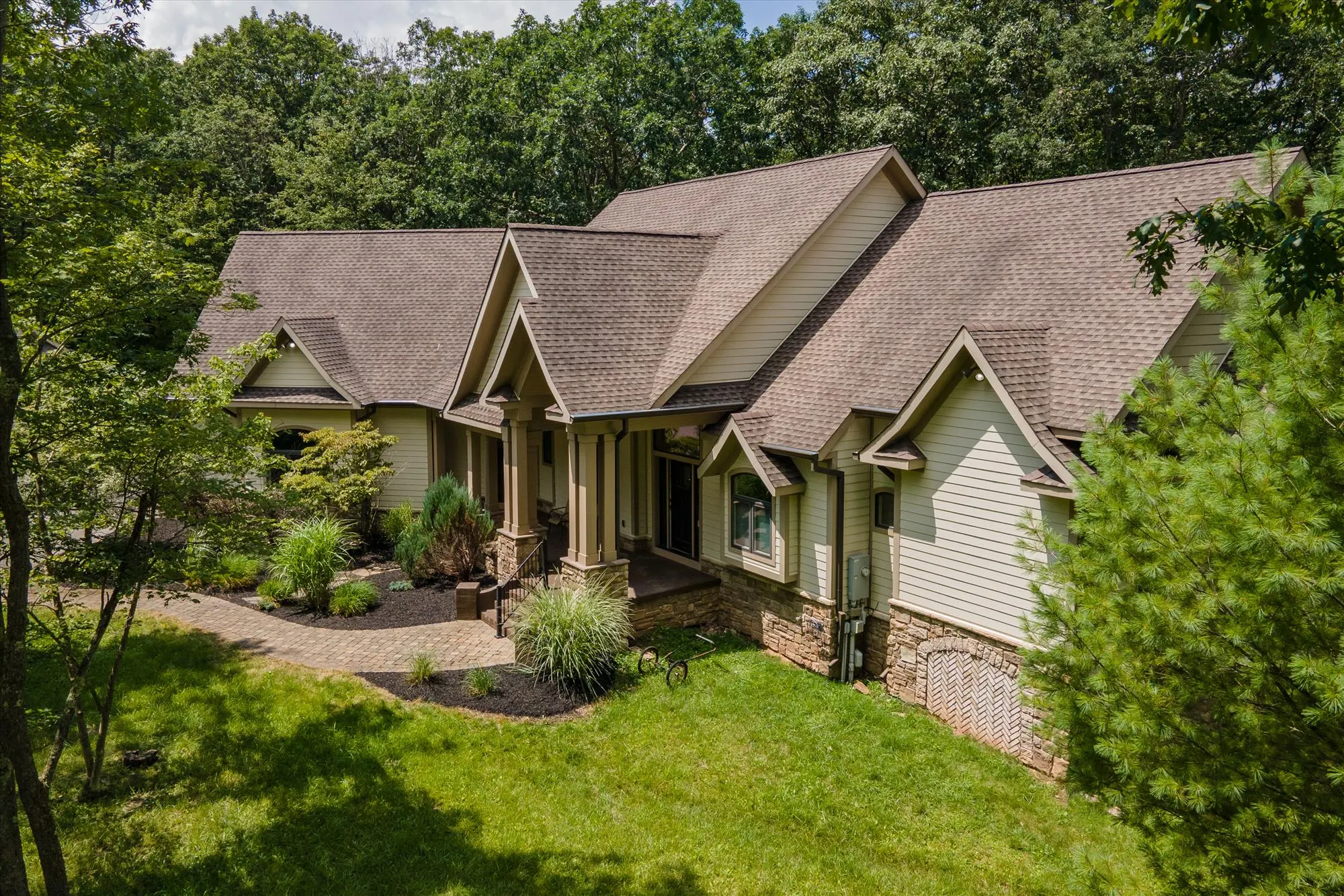 Rear exterior of Woodland Chalet highlighting wraparound deck and natural setting
