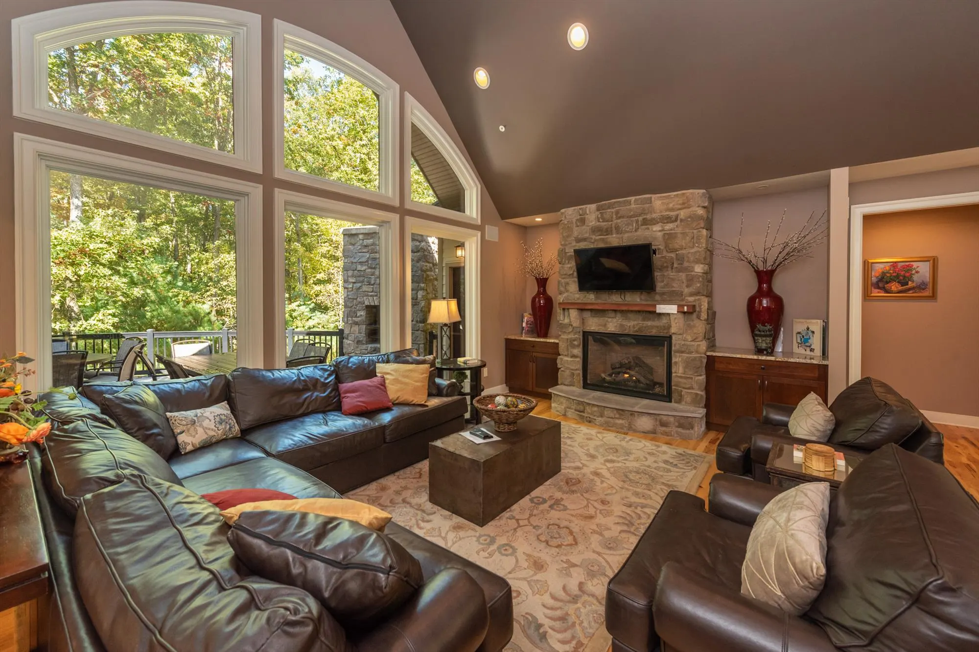 Spacious living room with stone fireplace and cathedral ceilings at Woodland Chalet