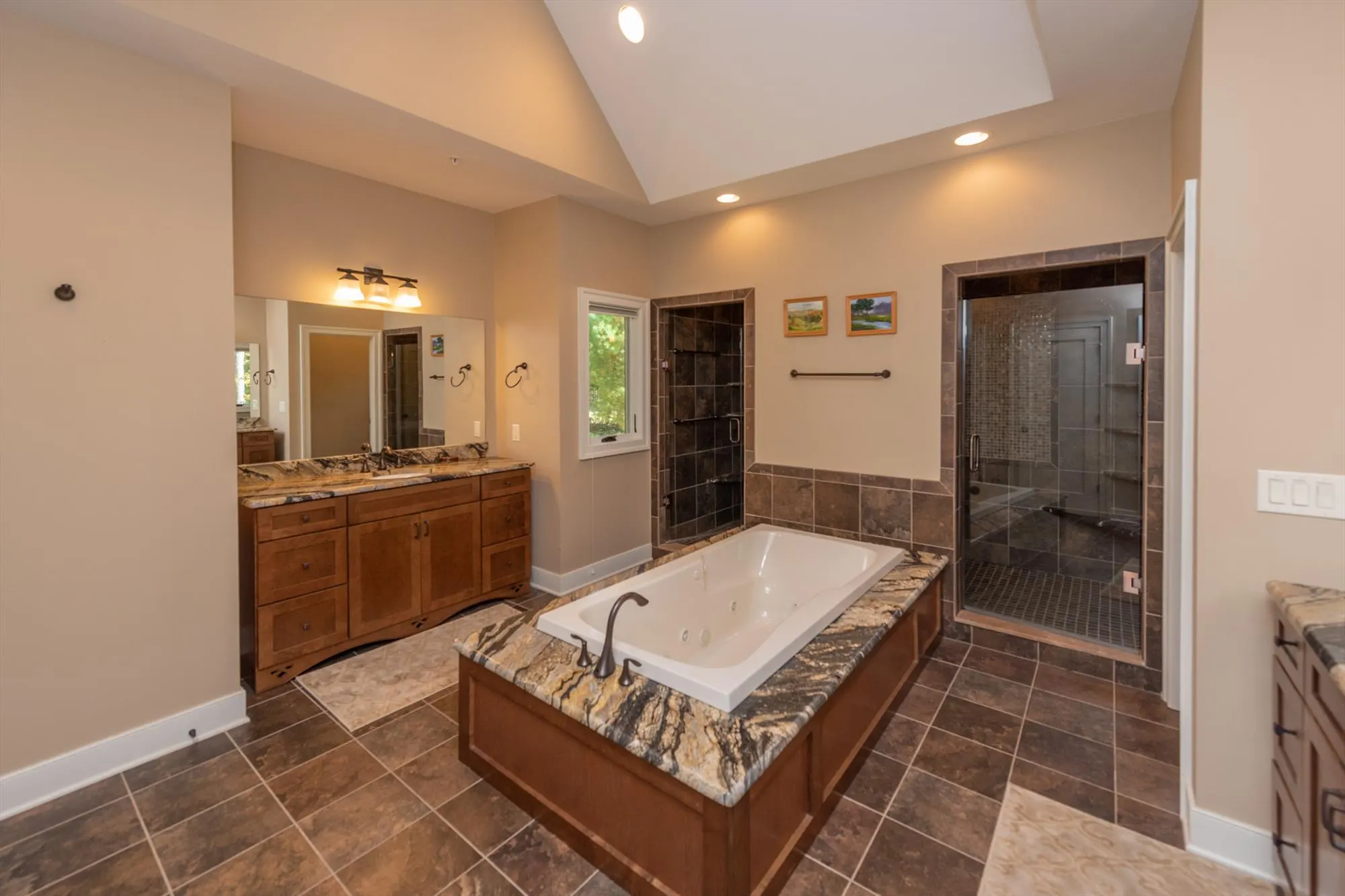 Main level primary suite bathroom with double vanity and elegant finishes